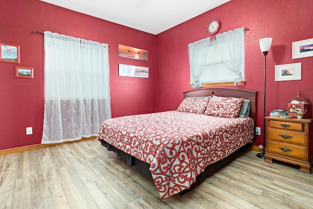 bedroom featuring hardwood / wood-style flooring and multiple windows