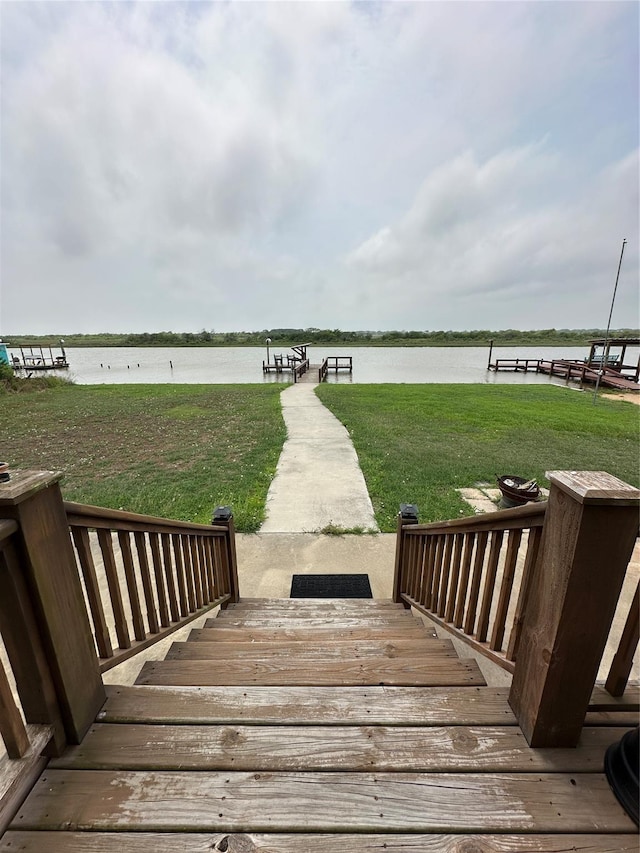 exterior space with a water view and a lawn