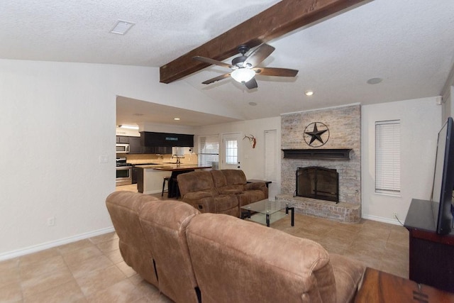 living room featuring a textured ceiling, a fireplace, vaulted ceiling with beams, ceiling fan, and light tile patterned floors