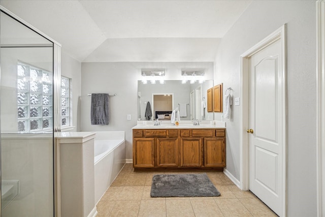 bathroom featuring vanity, tile patterned floors, a healthy amount of sunlight, and vaulted ceiling