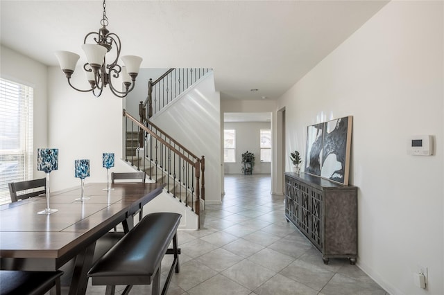 dining area featuring a wealth of natural light, light tile patterned floors, and a notable chandelier