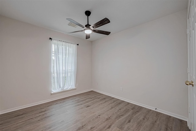 empty room with ceiling fan and light hardwood / wood-style flooring