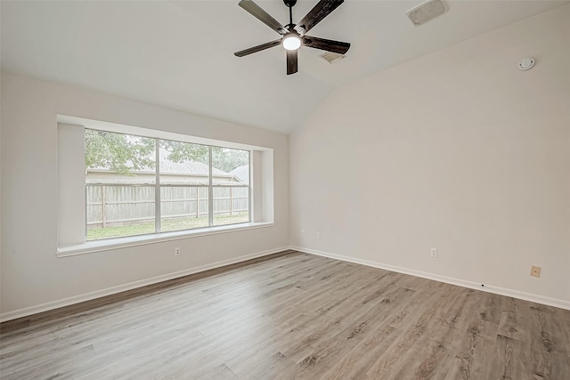 empty room featuring ceiling fan, light hardwood / wood-style flooring, and vaulted ceiling