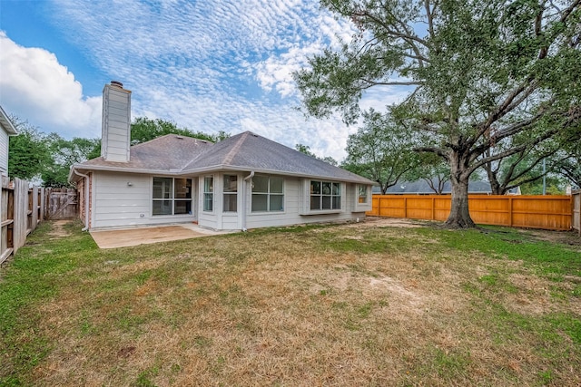 rear view of property with a patio and a lawn