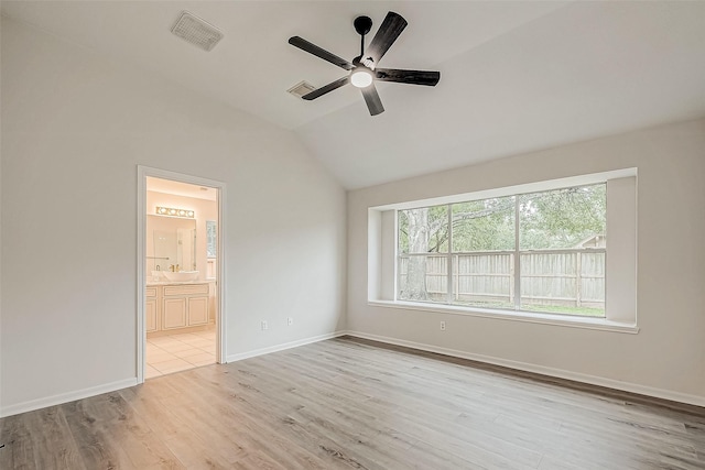 unfurnished bedroom with lofted ceiling, ensuite bath, ceiling fan, and light hardwood / wood-style floors