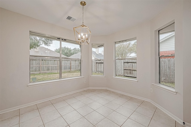 unfurnished dining area with light tile patterned floors, an inviting chandelier, and a healthy amount of sunlight