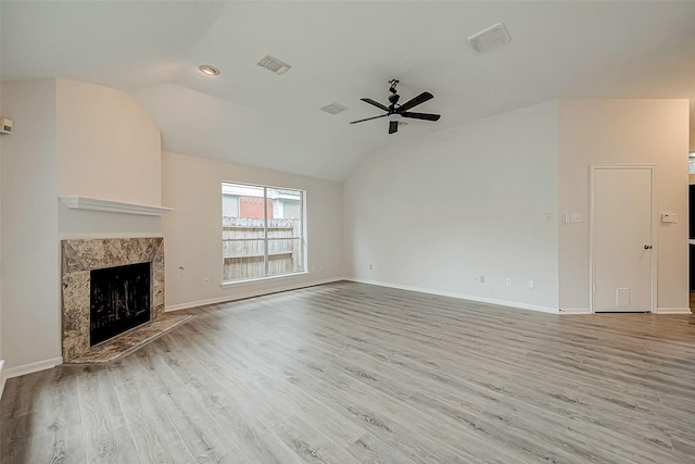 unfurnished living room featuring a fireplace, ceiling fan, vaulted ceiling, and light hardwood / wood-style flooring