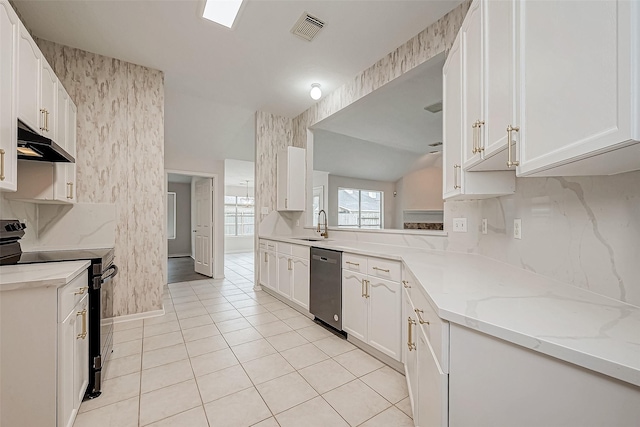 kitchen with dishwasher, light stone counters, sink, white cabinetry, and black / electric stove