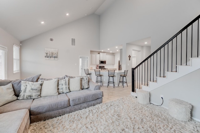 living room featuring high vaulted ceiling