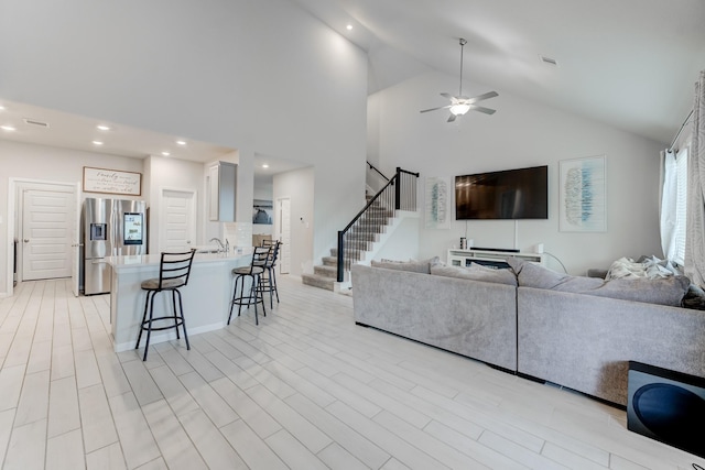 living room with high vaulted ceiling, ceiling fan, and sink