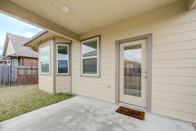 view of exterior entry with a patio area