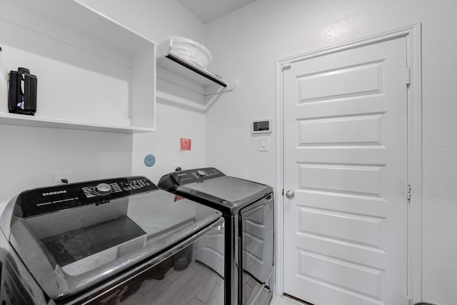 laundry area with washing machine and dryer and hardwood / wood-style flooring