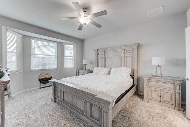 bedroom featuring multiple windows, light carpet, and ceiling fan