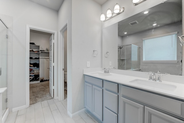 bathroom with toilet, an enclosed shower, and vanity