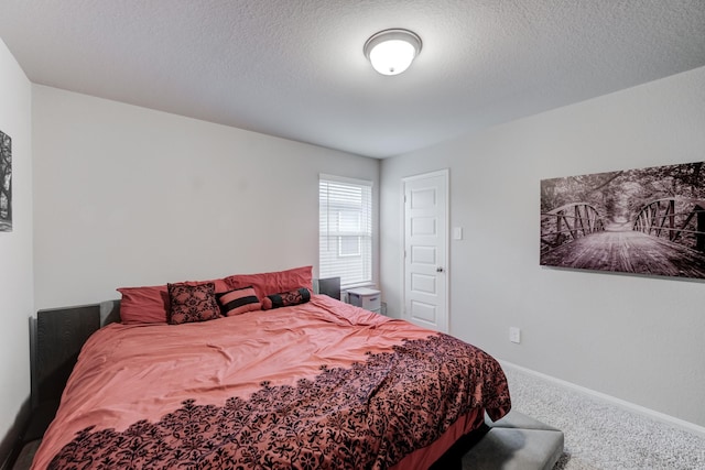 bedroom featuring a textured ceiling and carpet floors