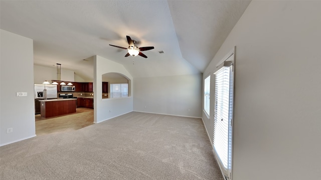 unfurnished living room featuring lofted ceiling, light colored carpet, and ceiling fan