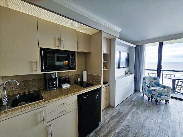 kitchen featuring black appliances, light hardwood / wood-style floors, stone counters, crown molding, and sink