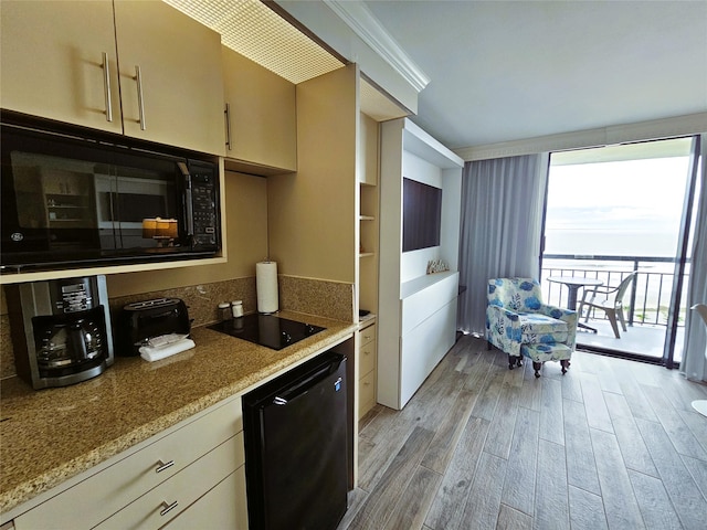 kitchen with ornamental molding, cream cabinets, black appliances, and light hardwood / wood-style floors