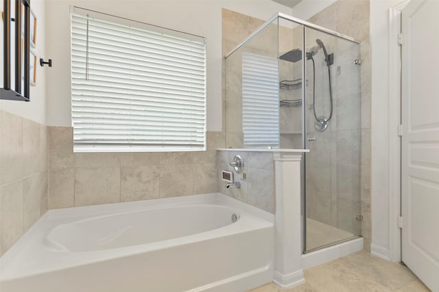 bathroom featuring a healthy amount of sunlight, tile patterned flooring, and plus walk in shower