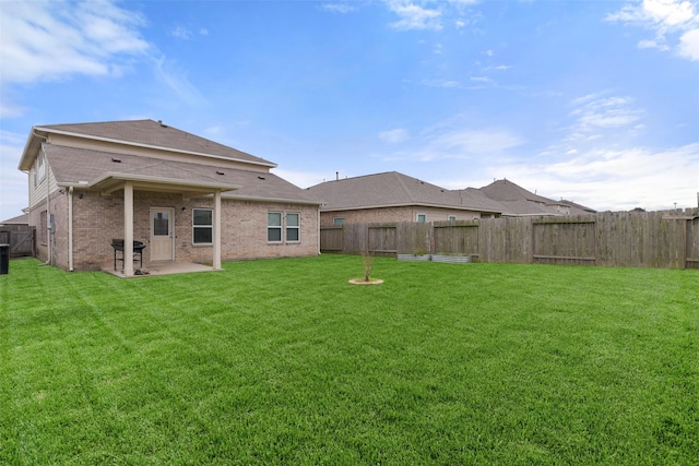 back of house featuring a lawn and a patio