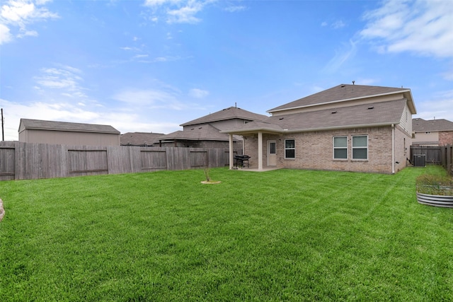 rear view of property with a yard, central AC, and a patio area