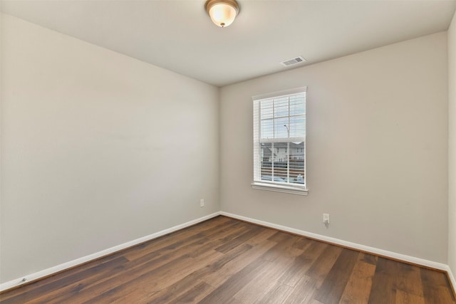 unfurnished room with dark hardwood / wood-style flooring