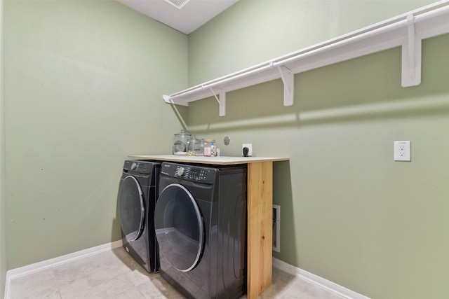 washroom featuring washing machine and dryer and light tile patterned floors