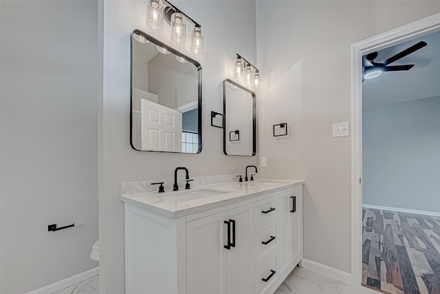 bathroom with toilet, vanity, and ceiling fan