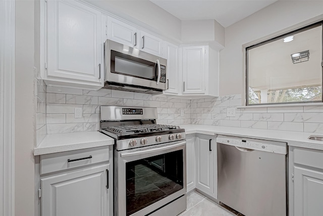 kitchen with white cabinets, stainless steel appliances, and light tile patterned floors