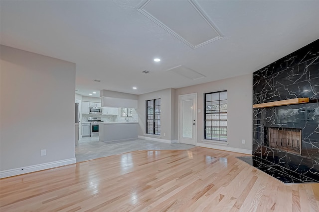 unfurnished living room with a fireplace and light hardwood / wood-style floors