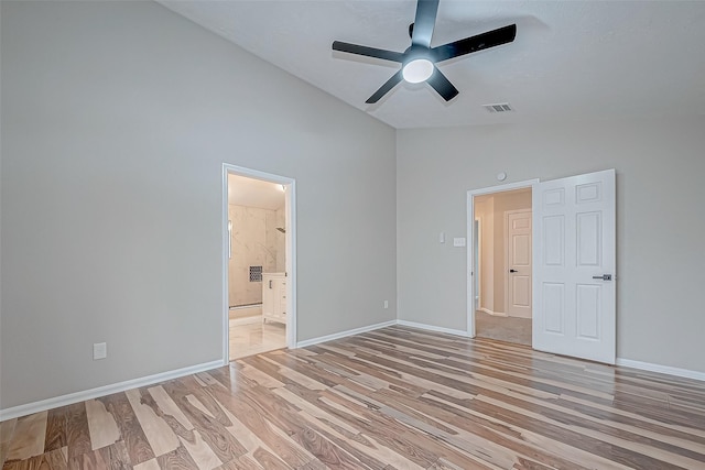 unfurnished bedroom featuring ensuite bath, light wood-type flooring, high vaulted ceiling, and ceiling fan