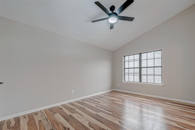 spare room featuring ceiling fan, light wood-type flooring, and vaulted ceiling