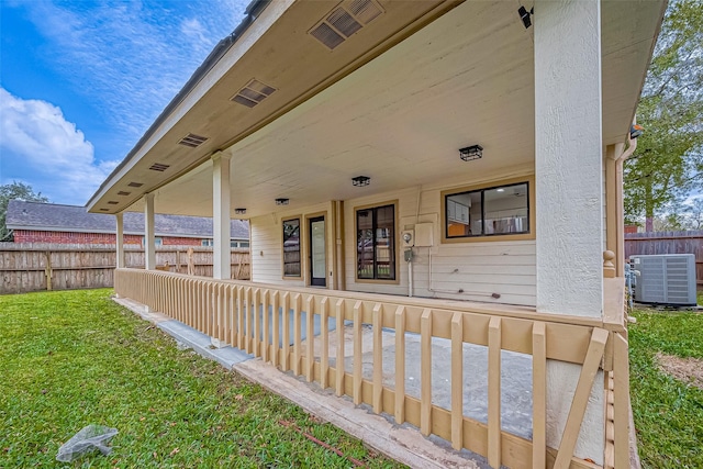 entrance to property with central AC and a yard