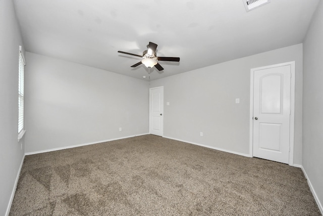 unfurnished room featuring ceiling fan and dark carpet