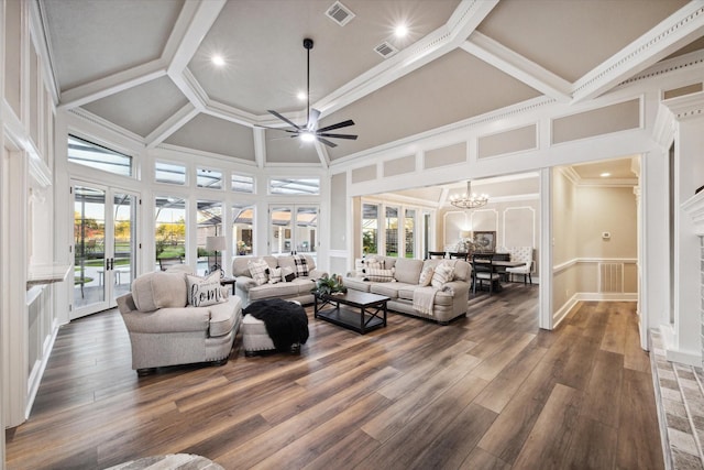 living room featuring a towering ceiling, ornamental molding, dark hardwood / wood-style flooring, and ceiling fan with notable chandelier