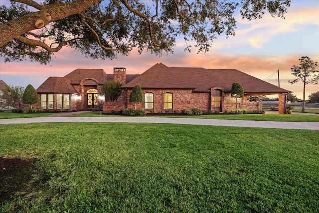 french country style house with a yard