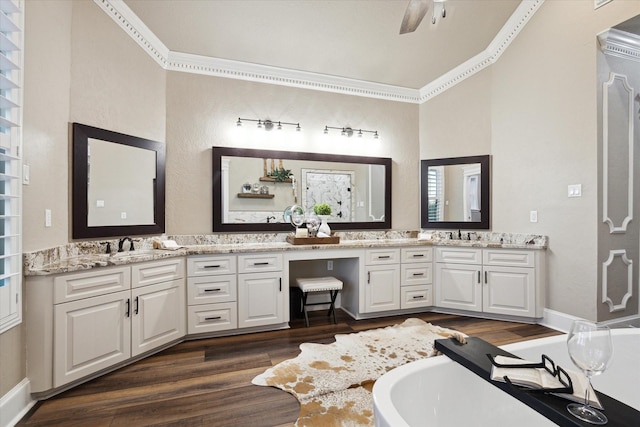 bathroom featuring ornamental molding, a tub, vanity, and hardwood / wood-style flooring