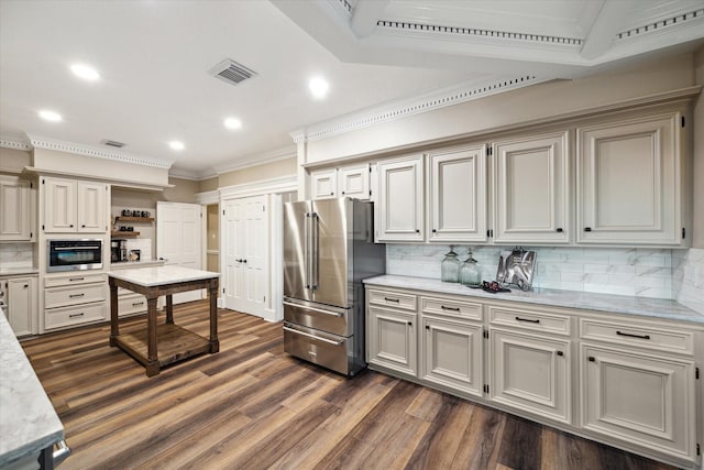 kitchen with light stone counters, dark hardwood / wood-style floors, tasteful backsplash, appliances with stainless steel finishes, and ornamental molding