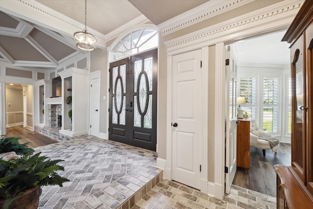 foyer entrance featuring french doors, an inviting chandelier, and crown molding