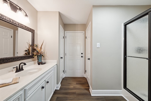 bathroom with an enclosed shower, vanity, and hardwood / wood-style flooring