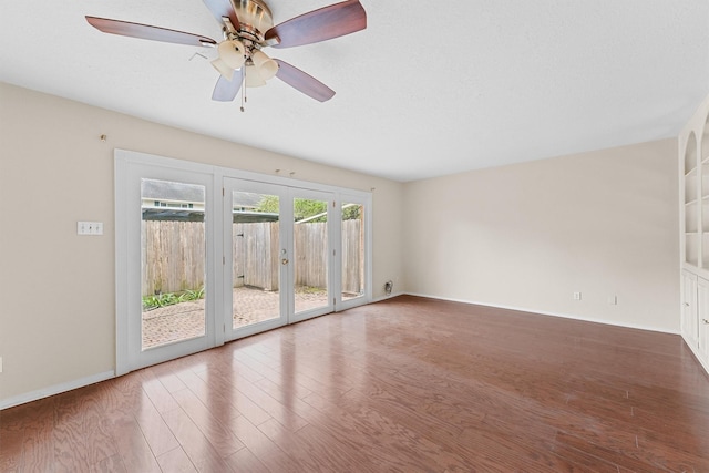 empty room featuring ceiling fan, french doors, and hardwood / wood-style floors