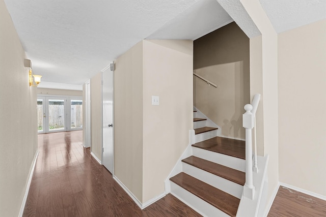 stairway featuring wood-type flooring and a textured ceiling