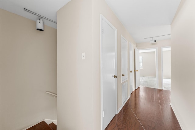 hallway with track lighting and dark hardwood / wood-style flooring