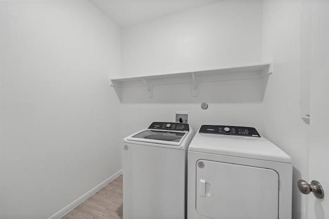 washroom with separate washer and dryer and light hardwood / wood-style flooring