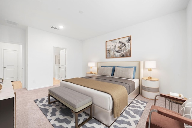 bedroom with ensuite bath and light colored carpet