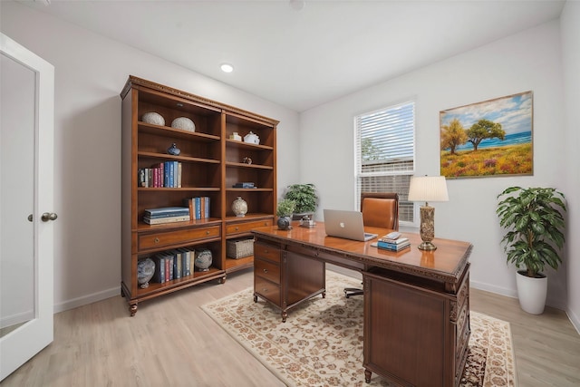 home office with light hardwood / wood-style flooring