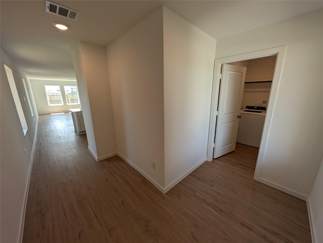 corridor with light hardwood / wood-style flooring and washer / clothes dryer