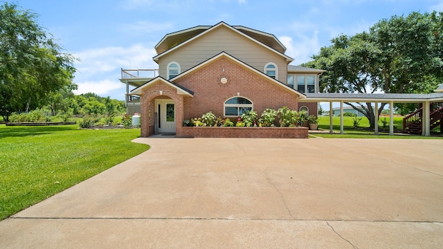 view of front of house featuring a balcony, a carport, and a front lawn