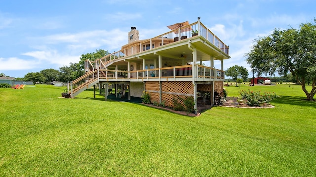 rear view of house with a wooden deck, a lawn, and ceiling fan