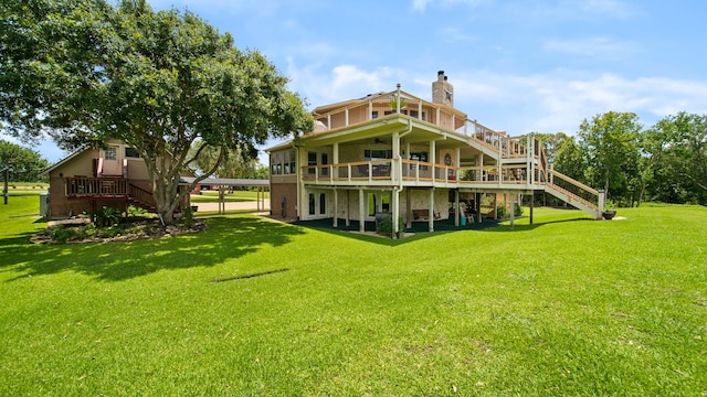 rear view of property with a wooden deck and a lawn